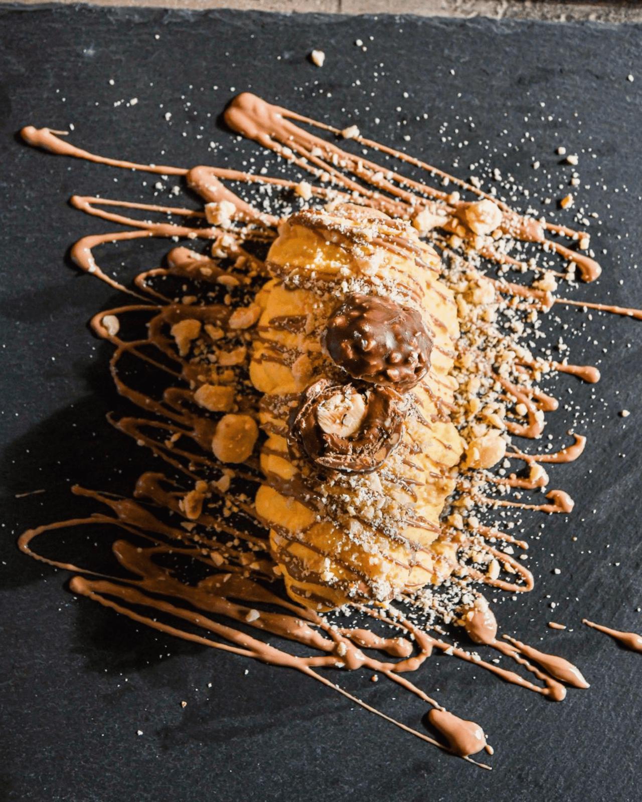 Tiramisù Ferrero Rocher con cioccolato e nocciole colati sull'ardesia