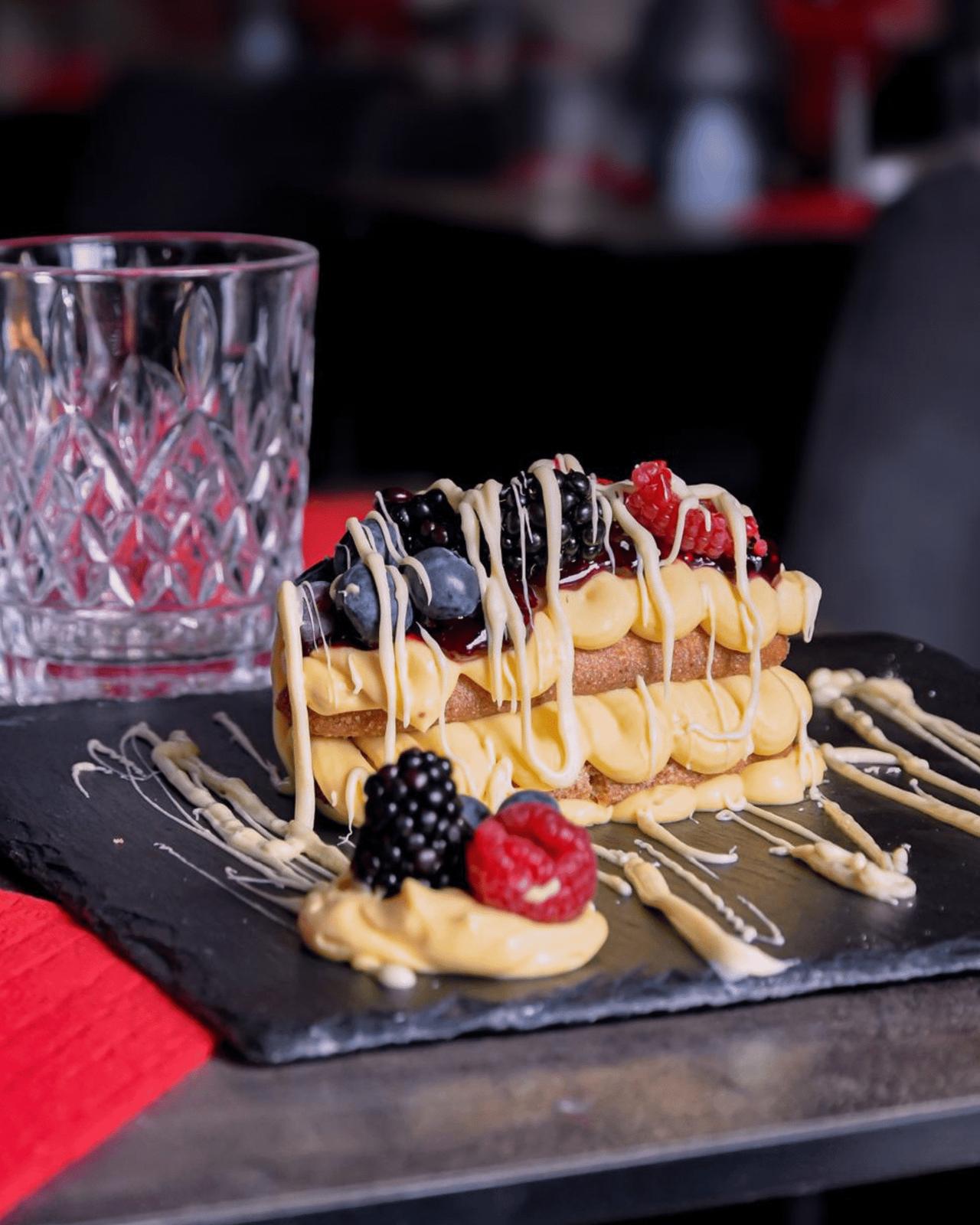 Tiramisù ai frutti di bosco con more, lamponi e crema bianca colata