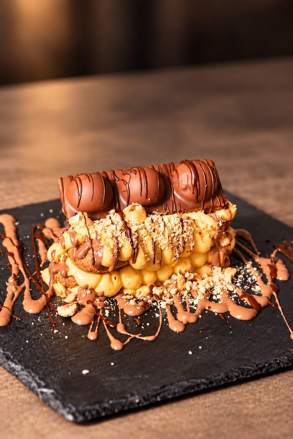 Tiramisù Kinder Bueno con le barrette sopra e cioccolato colato sull'ardesia